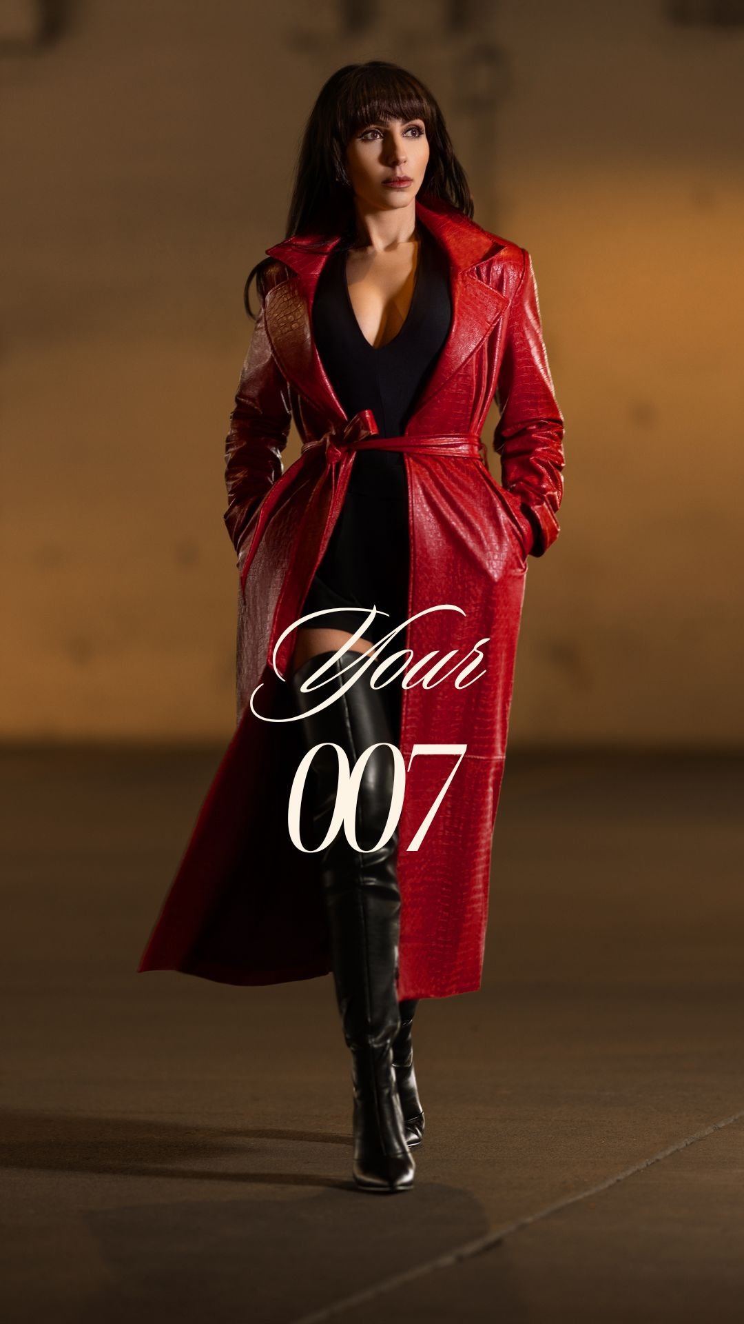 Channel your inner spy with our 'Hour 007' fashion series. Captured here is a model exuding mystery and allure, dressed in a striking red leather trench coat, cinched at the waist with a black belt, and paired with sleek knee-high boots. She stands poised against a moody backdrop, embodying the enigmatic charm of a fashion-forward secret agent